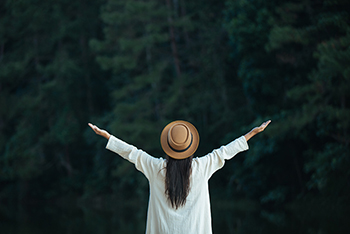 picture of a woman sprading her arms looking at nature